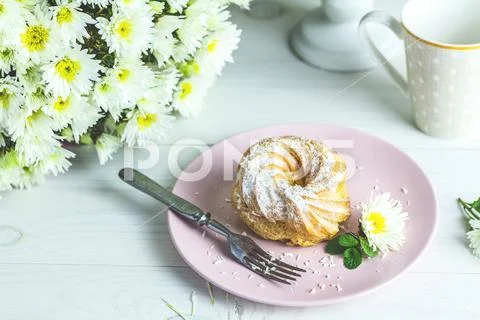 Delicious cakes with coconut chips on pink plate on white table Stock Photos