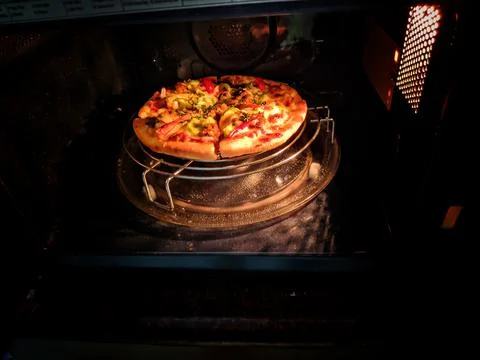 Delicious cheese stringy slice lifted of full supreme pizza baked fresh out o Stock Photos
