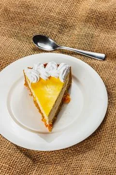 Delicious cheesecake slice with mango topping on rustic background setting Stock Photos