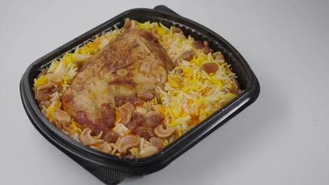 Delicious chicken biryani served with rice and nuts in a takeout container Stock Footage 345697188