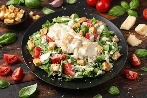 A delicious chicken caesar salad with parmesan cheese, tomatoes, croutons and Stock Photos