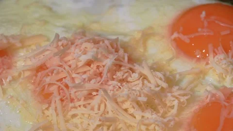 Delicious chicken eggs are fried in vegetable oil in a pan and sprinkled with Stock Footage 228216824