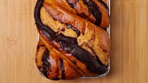 Delicious chocolate babka bread resting on wooden table Video stock 315424457