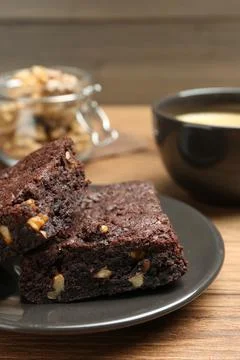 Delicious chocolate brownies with nuts on wooden table, closeup Stock Photos