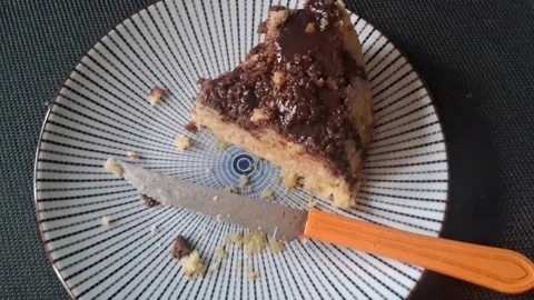 Delicious chocolate cake slice on patterned plate in motion video Stock Footage 339248256