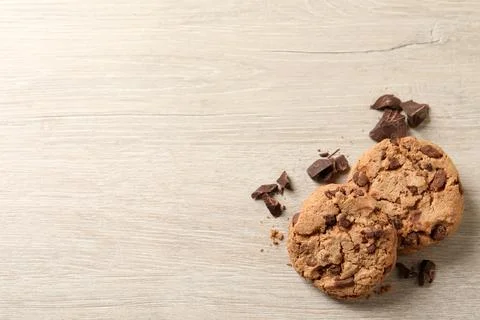 Delicious chocolate chip cookies on wooden table, flat lay. Space for text Stock Photos