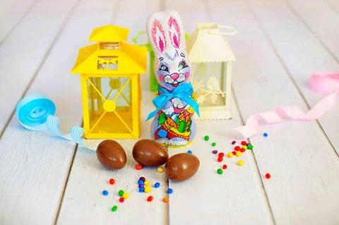 Delicious chocolate easter eggs and sweets and rabbit on wooden background Stock Photos