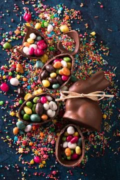 Delicious chocolate easter eggs ,bunny and sweets on dark blue background Stock Photos