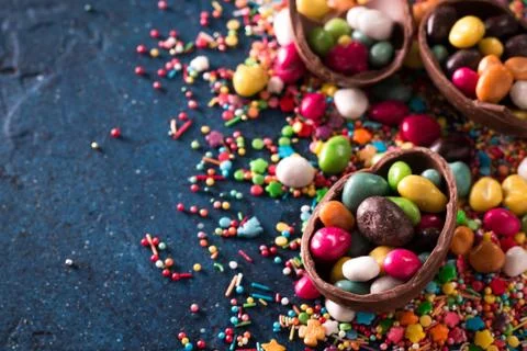Delicious chocolate easter eggs ,bunny and sweets on dark blue background Stock Photos