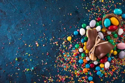 Delicious chocolate easter eggs ,bunny and sweets on dark blue background Stock Photos