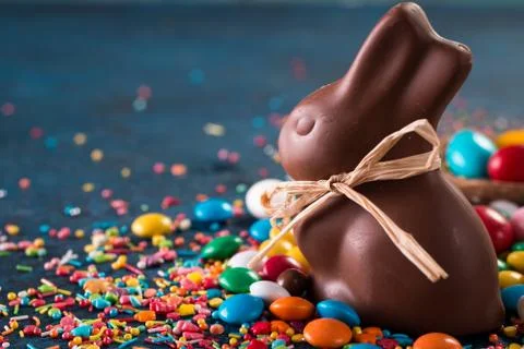 Delicious chocolate easter eggs ,bunny and sweets on dark blue background Stock Photos