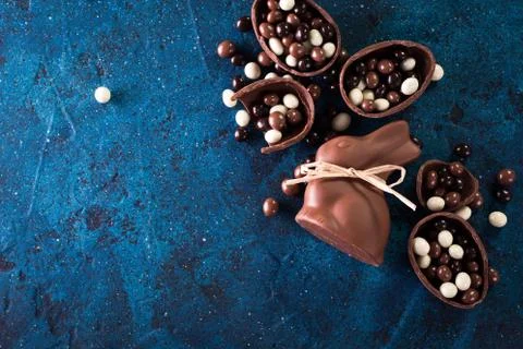 Delicious chocolate easter eggs ,bunny and sweets on dark blue background Stock Photos