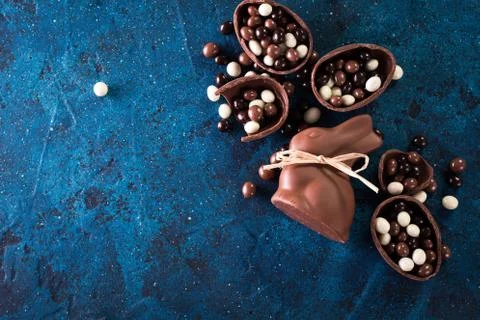 Delicious chocolate easter eggs ,bunny and sweets on dark blue background Foto stock