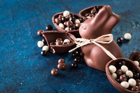 Delicious chocolate easter eggs ,bunny and sweets on dark blue background Stock Photos