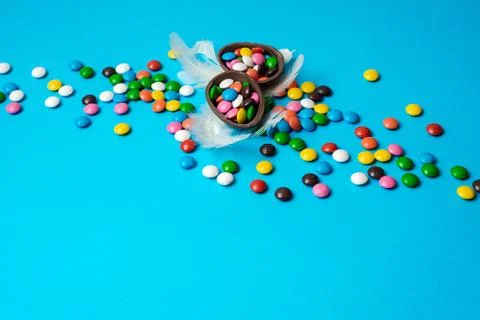 Delicious chocolate easter eggs, sweets on blue background Stock Photos