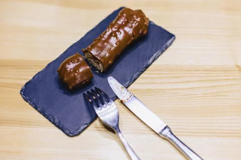 Delicious chocolate eclair with a fork and a knife Stock Photos