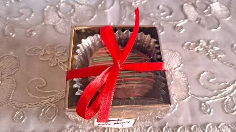 Delicious chocolate truffle inside a small square box with red ribbon Stock Photos