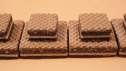 Delicious chocolate waffles with hazelnuts on an orange background. Stock Footage 252522733