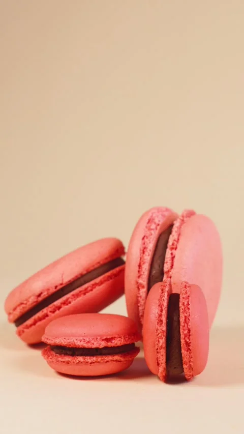Delicious classic pink macarons in motion on a beige background. Stock Footage 236687889