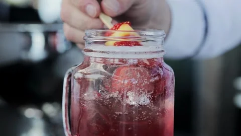 Delicious cocktail with lemonade and red strawberries, close-up. Slow motion Stock Footage 315282933