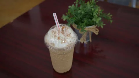 A delicious cold iced coffee drink served in a clear plastic cup with a pink Stock Footage 337228740