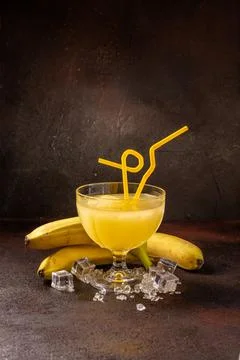 Delicious cold refreshing ananas smoothie drink in cocktail glass with banana Stock Photos