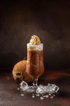 Delicious cold refreshing ice coffee in cocktail glass with coconut Stock Photos