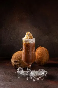Delicious cold refreshing ice coffee in cocktail glass with coconut Stock Photos