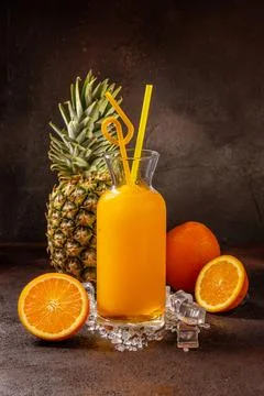 Delicious cold refreshing orange smoothie drink in cocktail glass with ananas Stock Photos