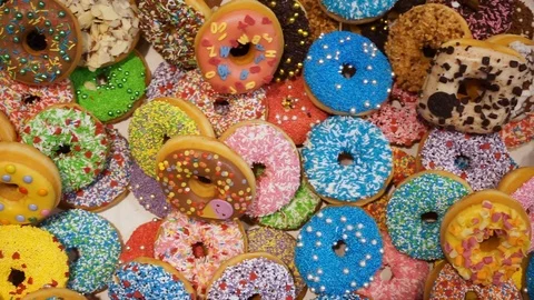 Delicious colored donuts in the shop window Stock Footage 107909091
