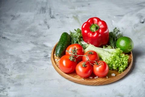 Delicious composition of assorted fresh vegetables and herbs on white textured Photos