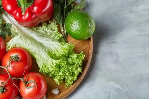 Delicious composition of assorted fresh vegetables and herbs on white textured Photos