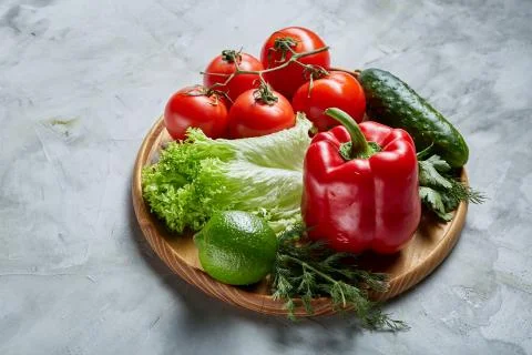 Delicious composition of assorted fresh vegetables and herbs on white textured Photos