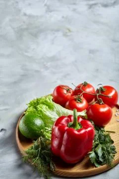 Delicious composition of assorted fresh vegetables and herbs on white textured Photos