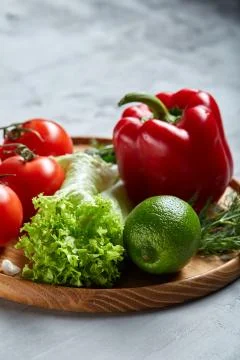 Delicious composition of assorted fresh vegetables and herbs on white textured Photos