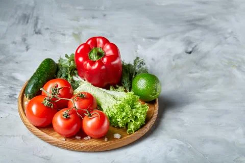 Delicious composition of assorted fresh vegetables and herbs on white textured Photos