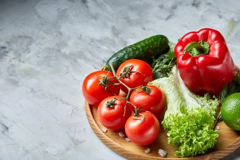 Delicious composition of assorted fresh vegetables and herbs on white textured Photos