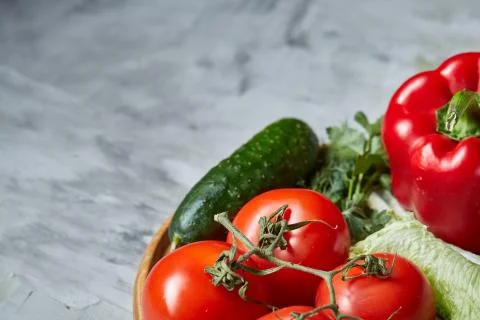 Delicious composition of assorted fresh vegetables and herbs on white textured Photos