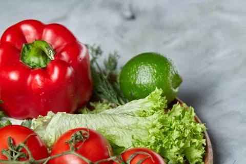 Delicious composition of assorted fresh vegetables and herbs on white textured Photos