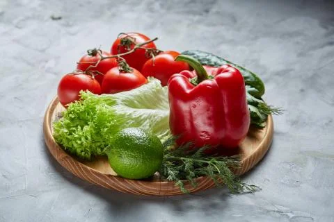 Delicious composition of assorted fresh vegetables and herbs on white textured Photos