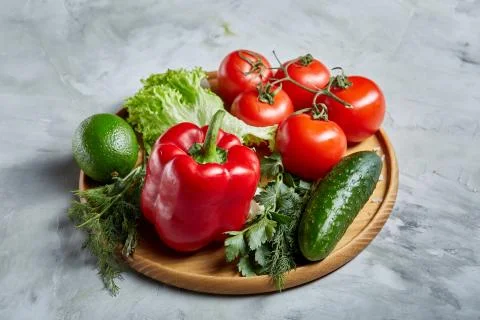 Delicious composition of assorted fresh vegetables and herbs on white textured Photos