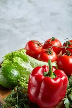 Delicious composition of assorted fresh vegetables and herbs on white textured Photos