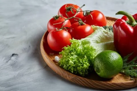 Delicious composition of assorted fresh vegetables and herbs on white textured Photos