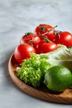 Delicious composition of assorted fresh vegetables and herbs on white textured Photos