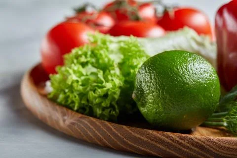 Delicious composition of assorted fresh vegetables and herbs on white textured Photos