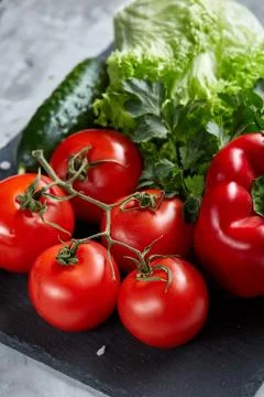 Delicious composition of assorted fresh vegetables and herbs on white textured Photos