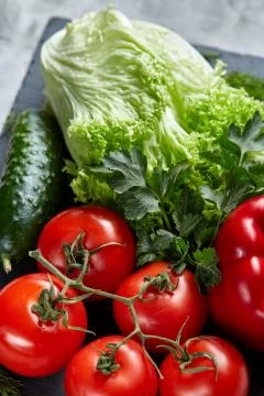 Delicious composition of assorted fresh vegetables and herbs on white textured Photos