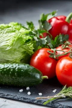 Delicious composition of assorted fresh vegetables and herbs on white textured Photos