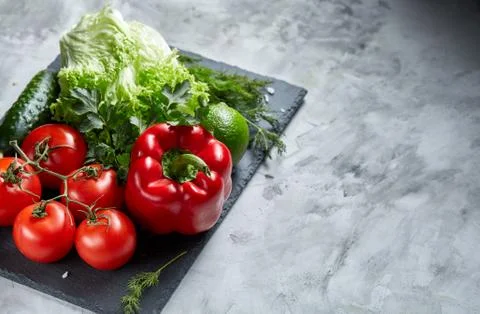 Delicious composition of assorted fresh vegetables and herbs on white textured Photos