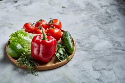 Delicious composition of assorted fresh vegetables and herbs on white textured Photos